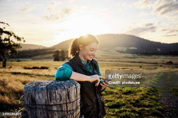 staying connected on the farm via mobile network - person looking at phone while smiling australia stock pictures, royalty-free photos & images