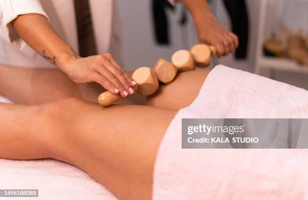 specialist giving a maderotherapy massage to a woman - massager stock pictures, royalty-free photos & images