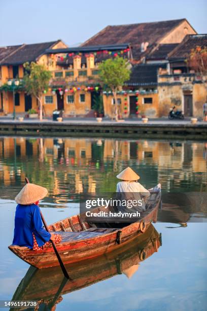 vietnamese women riding a boat, old town in hoi an city, vietnam - hoi an stockfoto's en -beelden