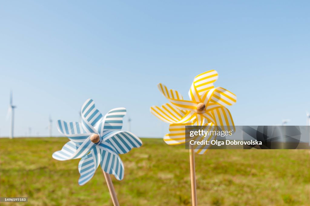 Toy windmills against a wind turbine field