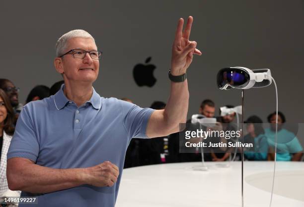 Apple CEO Tim Cook stands next to the new Apple Vision Pro headset is displayed during the Apple Worldwide Developers Conference on June 05, 2023 in...