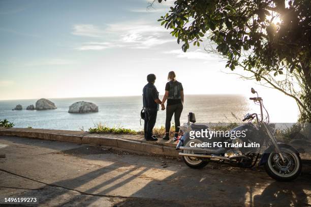 coppia matura che si rilassa e contempla su un viaggio in moto - mare moto foto e immagini stock