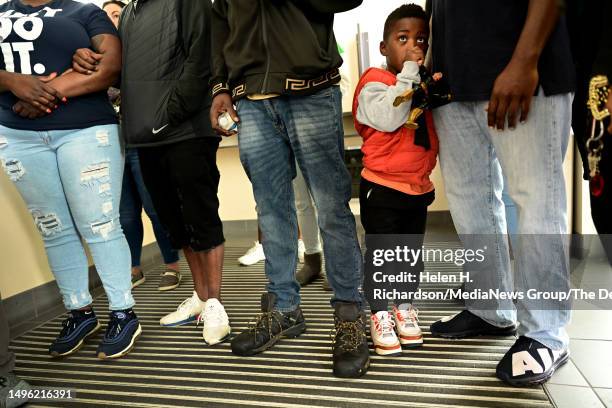 Dolan Boutwell cousin of 14-year-old shooting victim Jor'Dell Da'Shawn Richardson, stands close ot his father Dale, as the family members wait inside...