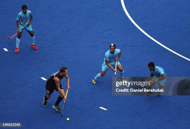 Ryan Archibald of New Zealand is challenged by Birendra Lakra and Sardar Singh of India as Danish Mujtaba, also of India, looks on during the men's...