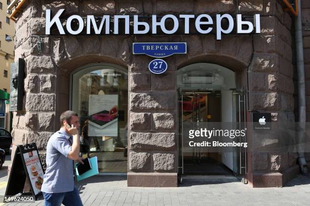 Pedestrian speaks on a mobile phone while passing a re:Store, a premium Apple product reseller, in Moscow, Russia, on Wednesday, Aug. 1, 2012. OAO...