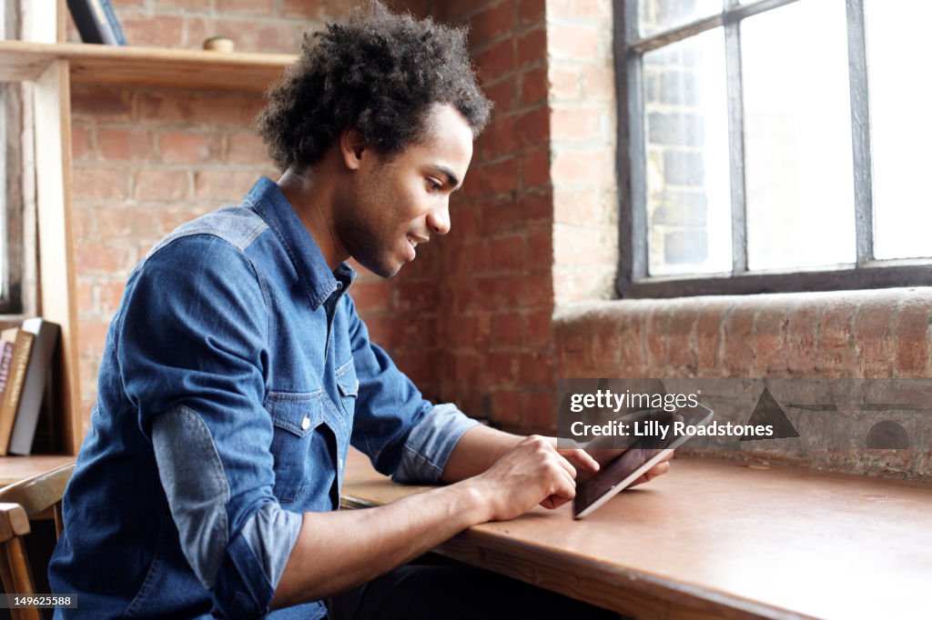 Young Guy Using Tablet Computer At Desk High-Res Stock Photo - Getty Images