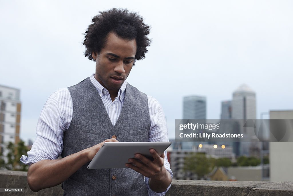 Young guy using tablet computer outside in London