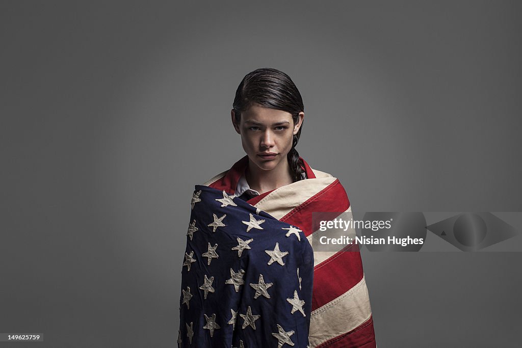 Portrait of woman wrapped in American flag