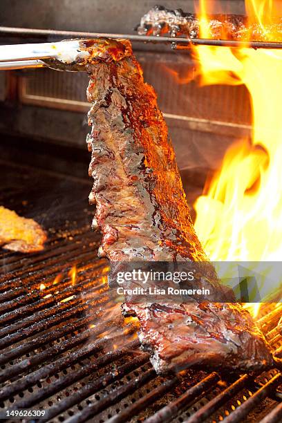 cooking racks of barbequed baby back ribs on grill - grill fire meat stockfoto's en -beelden
