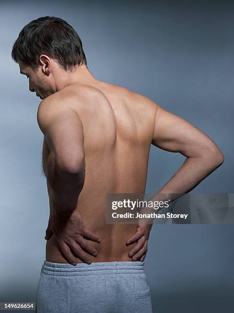 back shot of shirtless man, hands on lower back - lower back 個照片及圖片檔