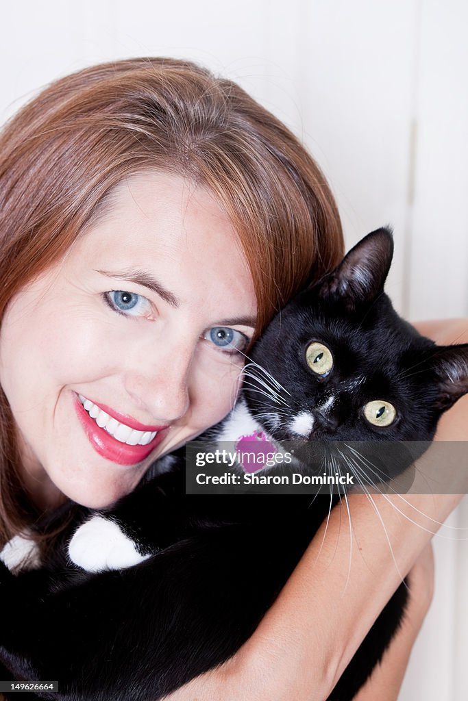 Smiling woman holding her pet cat