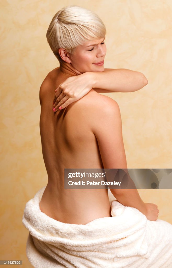 Girl with shoulder pain, massaging herself