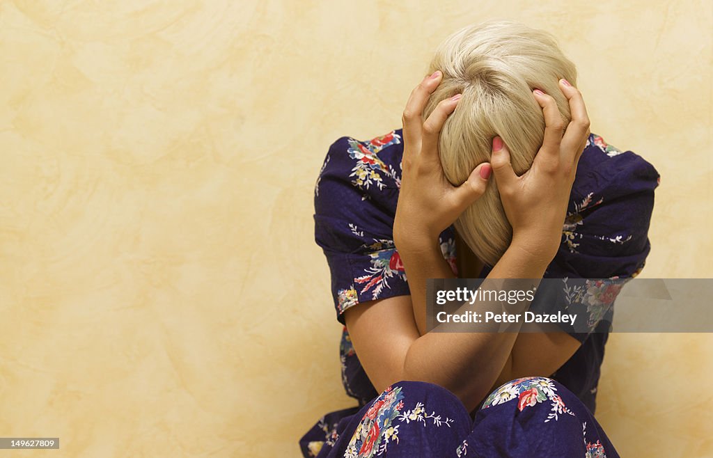 Woman clutching her head in mental anguish