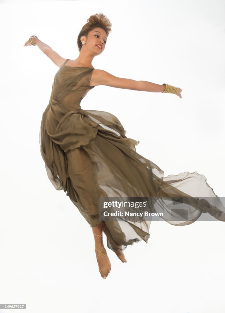 A mixed-race woman jumping for joy