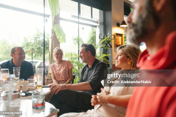 grupo de amigos en un café - mujeres de mediana edad fotografías e imágenes de stock