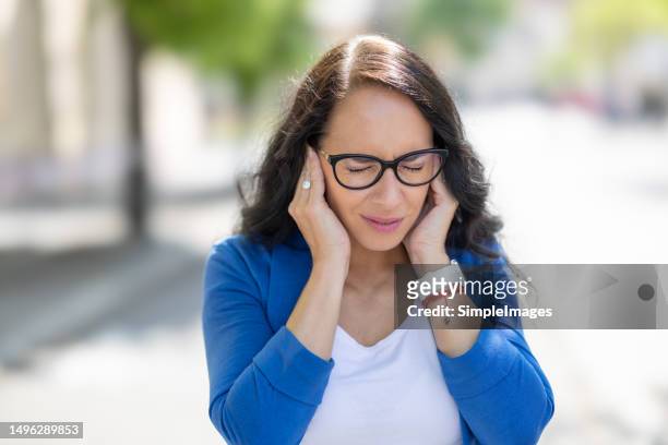 young business woman have headache migraine stress or tinnitus - noise whistling in her ears. - volume stock pictures, royalty-free photos & images