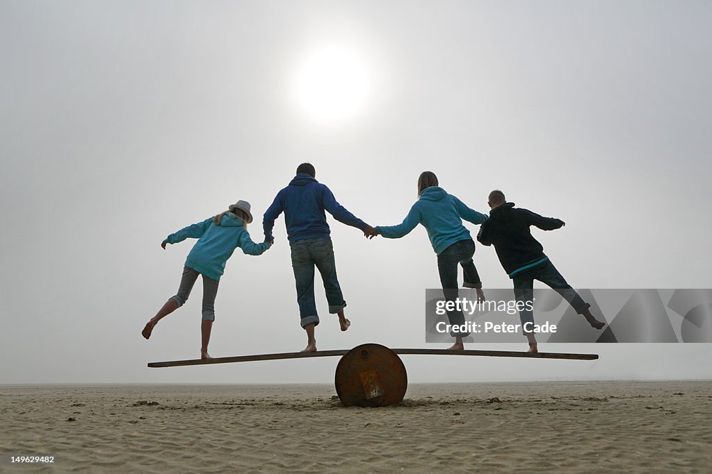 Family balancing on beach