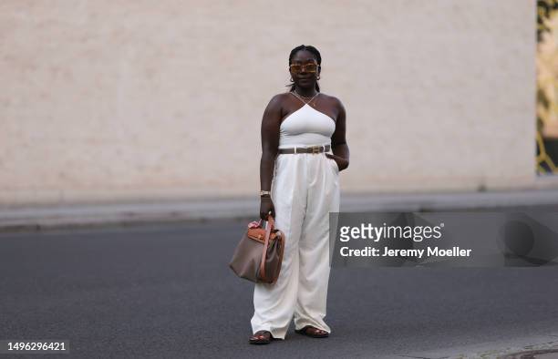 Lois Opoku wearing Rossi beige wide leg pants, H&M beige body, Lala Berlin black flip flops, Hermes Herbag Zip handbag and Hermes brown leather and...