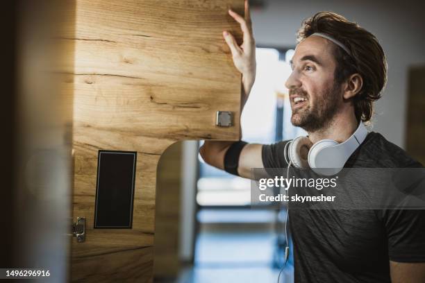 glücklicher athletischer mann in der umkleidekabine eines fitnessstudios. - spind stock-fotos und bilder