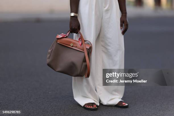 Lois Opoku wearing Rossi beige wide leg pants, H&M beige body, Lala Berlin black flip flops, Hermes Herbag Zip handbag and Hermes brown leather and...