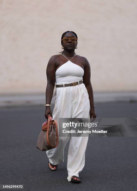 Lois Opoku wearing Rossi beige wide leg pants, H&M beige body, Lala Berlin black flip flops, Hermes Herbag Zip handbag and Hermes brown leather and...