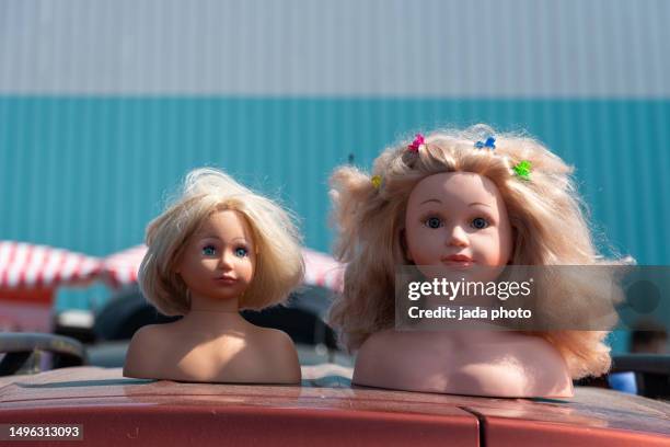 two bust of toy dolls lie outside on a roof of a car - baby doll stock pictures, royalty-free photos & images