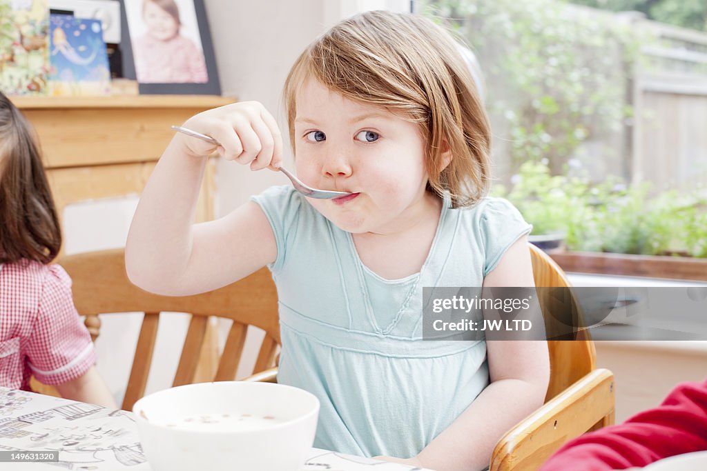 Girl (4-5) having cereals for breakfast