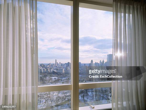 window with view of a snow covered central park - finestra foto e immagini stock