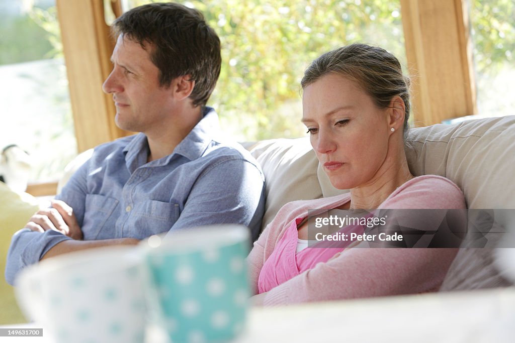 Couple sat down looking angry