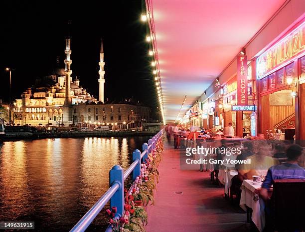 tourists dining along galata bridge at night - estambul fotografías e imágenes de stock