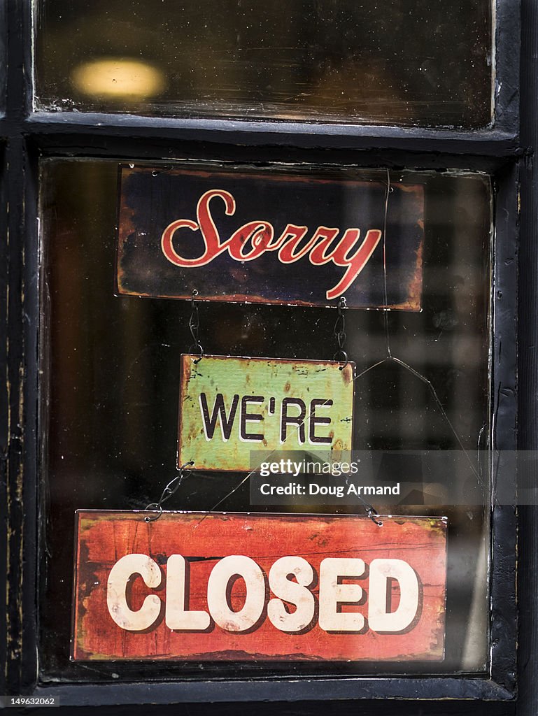 'Sorry we're closed', old signs in a shop window