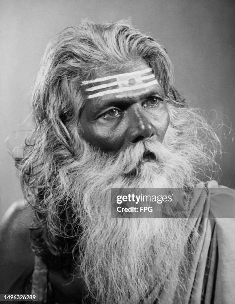 An Indian fakir with a long grey beard and facepaint comprising three horizontal white stripes on his forehead, circa 1935. Variously known as a...