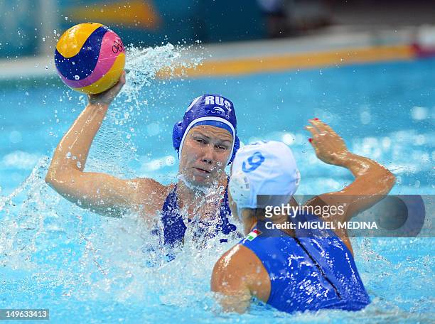 Russia's Olga Beliaeva is challenged by Italy's Giulia Rambaldi during the women’s water polo preliminary round groupe B match between Italy and...