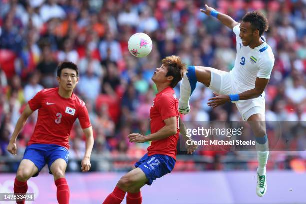 Seokho Hwang of Korea Republic is challenged by Pierre Aubameyang of Gabon during the Men's Football first round Group B Match between Korea Republic...