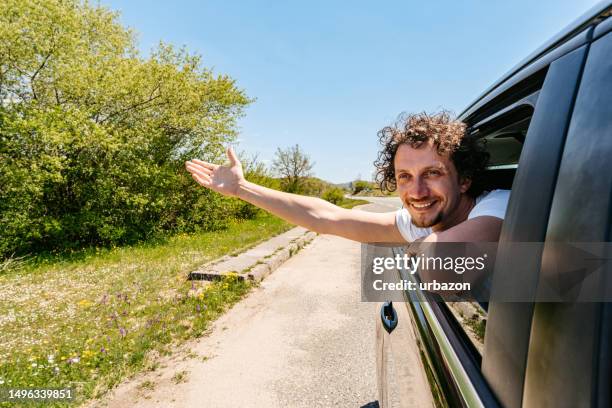 young man sticking his head out the car window - man head out car window stock pictures, royalty-free photos & images