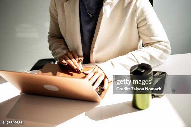a woman working at her desk with a laptop. - desk angle stock pictures, royalty-free photos & images