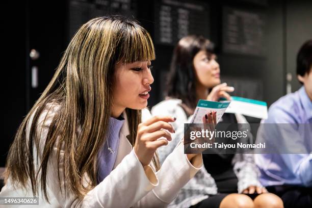 a female passenger checks her boarding pass in the departure area of an airport. - boarding pass stock-fotos und bilder