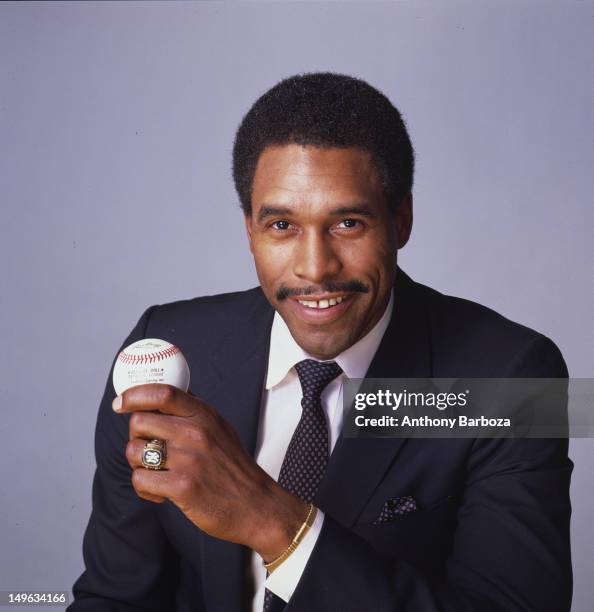 Portrait of American baseball player Dave Winfield, of the New York Yankees, dressed in a suit and tie as he holds a baseball in one hand, New York,...