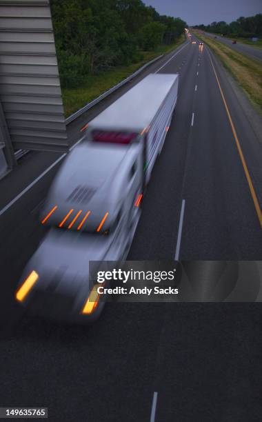 a semi-truck and trailer on a highway at dusk - chelsea michigan stock pictures, royalty-free photos & images