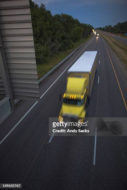 a semi-truck and trailer on a highway at dusk - chelsea michigan stock pictures, royalty-free photos & images