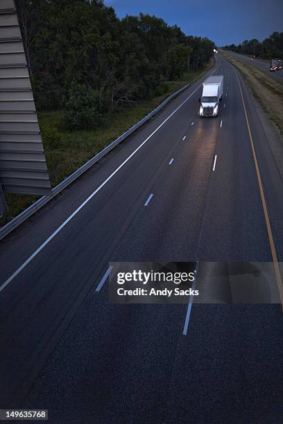 a semi-truck and trailer on a highway at dusk - chelsea michigan stock pictures, royalty-free photos & images