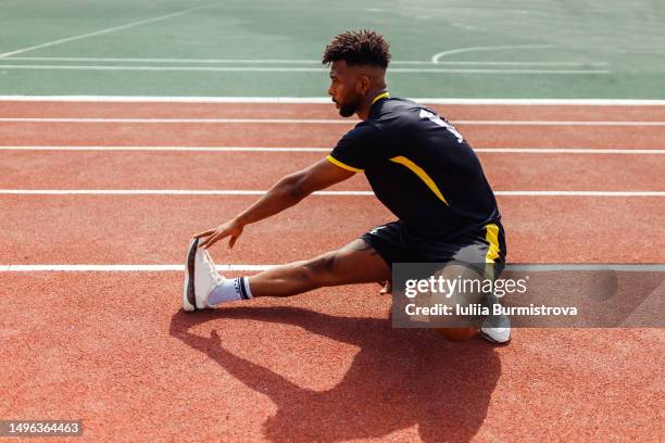 attractive male athlete of iranian ethnicity doing hamstring stretches to prepare for running - hamstring stock pictures, royalty-free photos & images