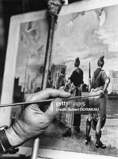 Main du peintre Alfred Courmes avec un pinceau peignant un tableau dans son atelier de la rue de Flandres à Paris en avril 1972.