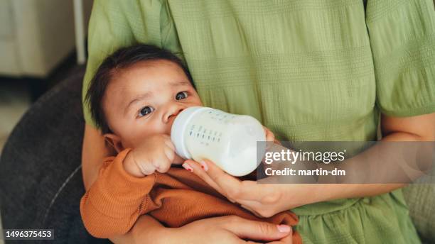 mother bottle-feeding her newborn baby boy - baby bottle stockfoto's en -beelden