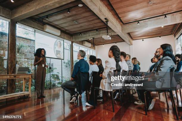 woman giving speaker presentation - conference presenter stock pictures, royalty-free photos & images