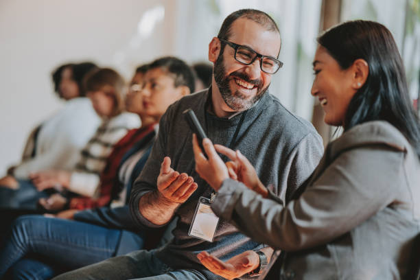 showing smartphone during conference - communication stock pictures, royalty-free photos & images