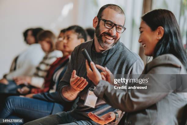 showing smartphone during conference - online connection stock pictures, royalty-free photos & images