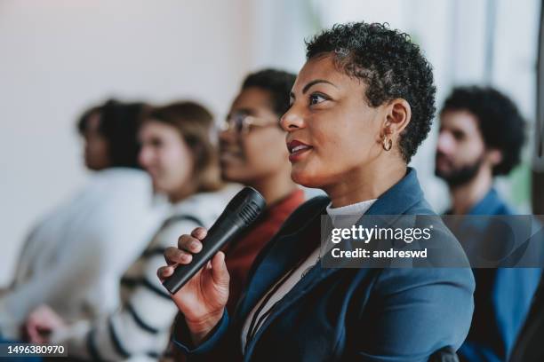 ask a question using microphone conference - vragen en antwoorden stockfoto's en -beelden