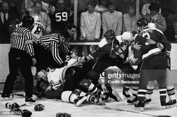 The Washington Capitals' Kevin Hatcher attempts to pull the Boston Bruins' Wade Campbell off teammate Steve Leach after a fight broke out when Leach...