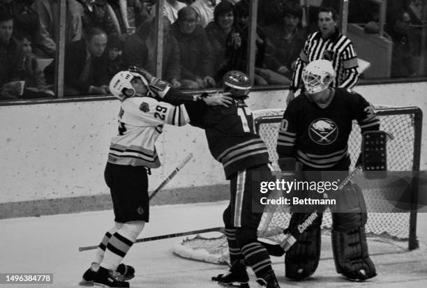 The Buffalo Sabres' Mike Foligno places his glove on the Boston Bruins' Luc Dufour's face during a fight in the first period of a game at the Boston...